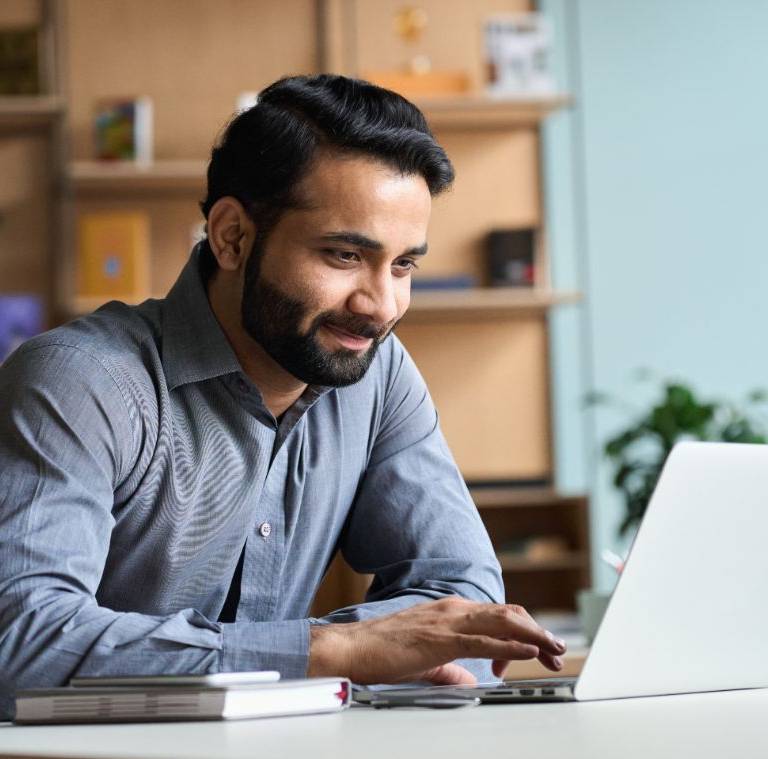 A digital marketing expert working on their laptop in an office space